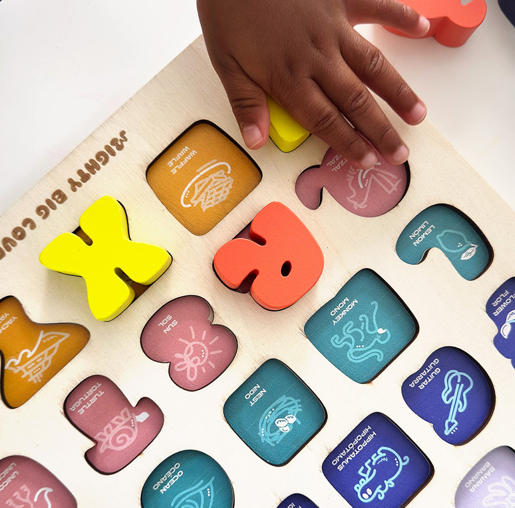 Child's hand interacting with a colorful alphabet puzzle on a white surface